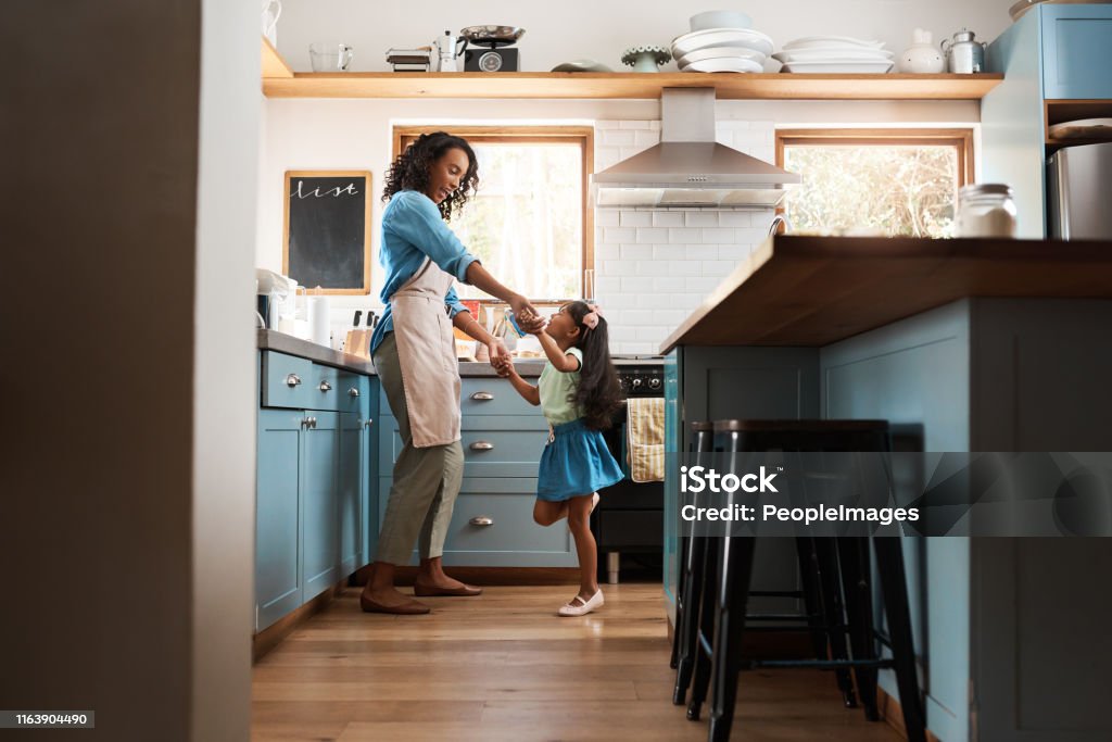 The kitchen is our happy place Shot of a young woman dancing with her daughter in the kitchen at home Family Stock Photo