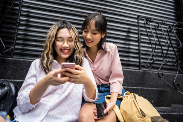 屋外の階段に座っている間、携帯電話を使用して台湾の女の子 - staircase steps education stone ストックフォトと画像