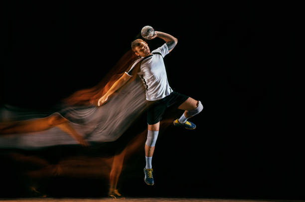 istock Young handball player against dark studio background in mixed light 1163905171