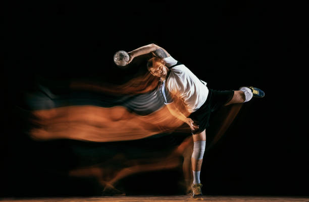 istock Young handball player against dark studio background in mixed light 1163905187