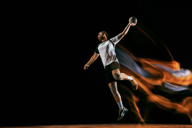 istock Young handball player against dark studio background in mixed light 1163905188