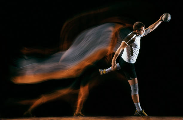 istock Young handball player against dark studio background in mixed light 1163905190