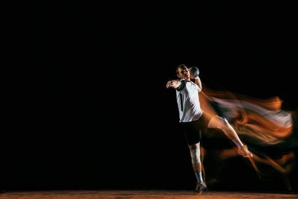 istock Young handball player against dark studio background in mixed light 1163905192