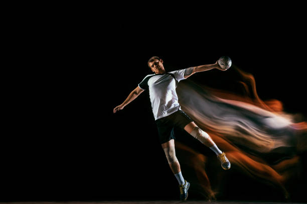 istock Young handball player against dark studio background in mixed light 1163905194