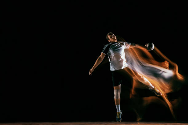 istock Young handball player against dark studio background in mixed light 1163905197