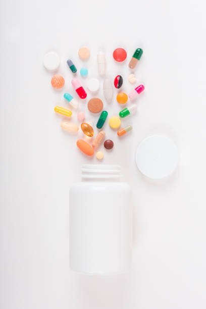 Assorted pharmaceutical medicine pills, tablets and capsules and bottle on white background. Copy space for text