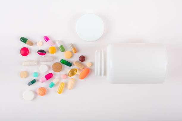 istock Assorted pharmaceutical medicine pills, tablets and capsules and bottle on white background. Copy space for text 1163905411