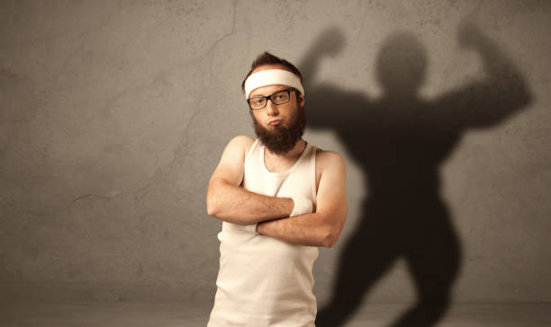istock Skinny man with musculous shadow 1163906302