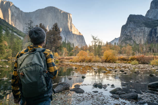 istock Young man contemplating Yosemite valley from the river, reflections on water surface 1163906513
