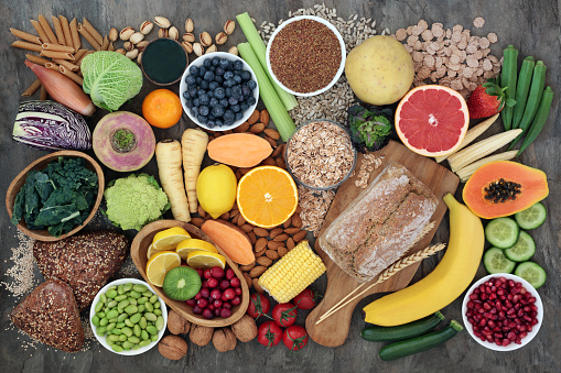 Overhead view of a large group of all sort of food for a well balanced and healthy diet of proteins, dietary fiber, carbohydrates, vitamins and minerals arranged side by side on white background. The composition includes fruits, vegetables, fish, raw meat, beans, seeds and nuts, pasta, cooking oil, spices and dairy products. High resolution 42Mp studio digital capture taken with SONY A7rII and Zeiss Batis 40mm F2.0 CF lens
