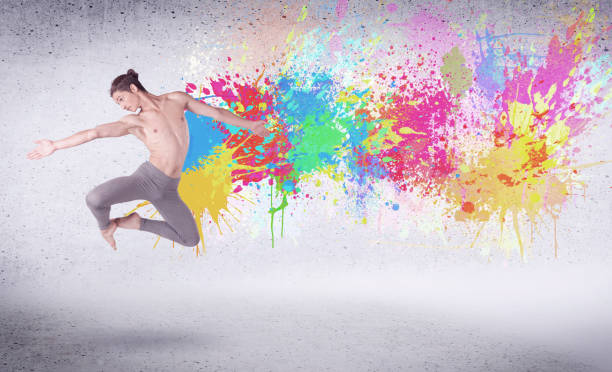 istock Modern street dancer jumping with colorful paint splashes 1163907303