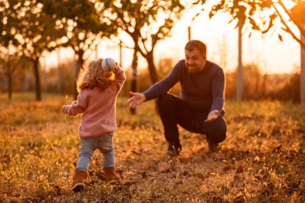 padre che gioca a prendere con la figlia bambino al parco - playing catch foto e immagini stock