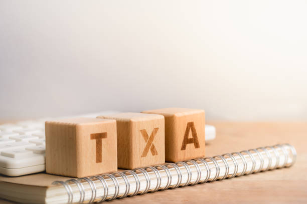 istock TAX on wooden surface on notebook. 1163907874