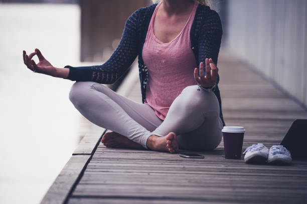 Unknown female doing yoga at pier.