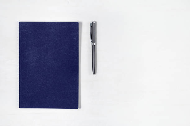 istock Blue copybook and metallic pen on light work space. Flat lay concept for school or business. Top view with copy space. 1163910729