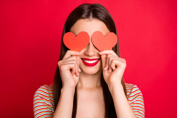 retrato de la foto del estudio de cerca de la señora bastante encantadora con la sonrisa radiante dentón sosteniendo dos pequeñas tarjetas de papel en las manos de fondo brillante aislado - venda de ojos fotografías e imágenes de stock