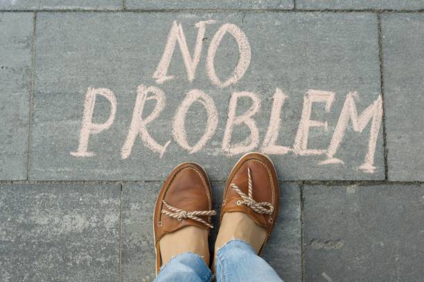 istock Female feet with text no problem written on grey sidewalk 1163911988