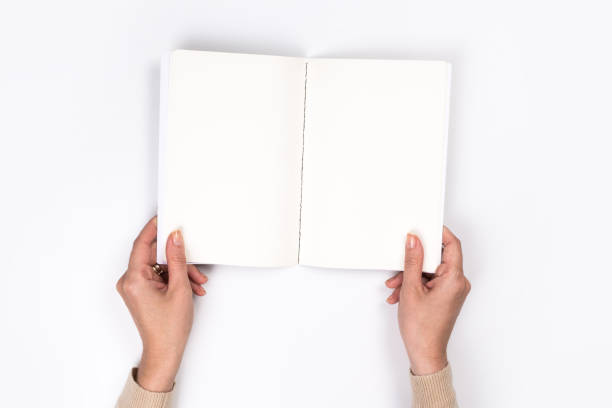 istock Woman's hands with perfect manicure holding  notepad as mockup for your design. White background, flat lay 1163912238