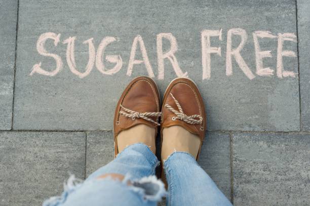 istock Female feet with text sugar free written on grey sidewalk 1163912542