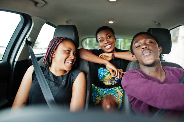 istock Young african american friends sitting inside a car. 1163914009