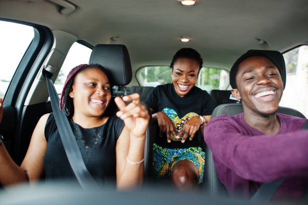 istock Young african american friends sitting inside a car. 1163914011