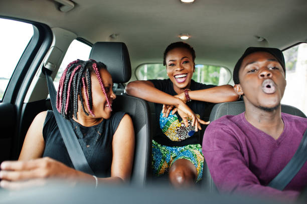 istock Young african american friends sitting inside a car. 1163914014