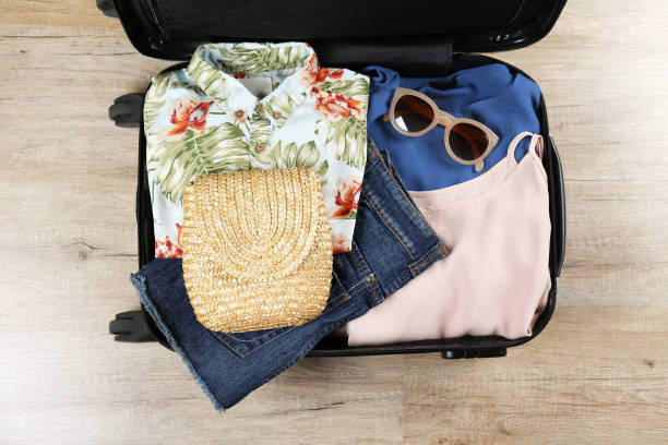 istock Plastic hardshell suitcase packed with casual clothing items. 1163915058