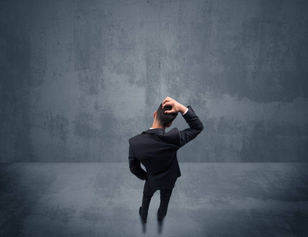 istock Businessman standing in front of urban wall 1163915287