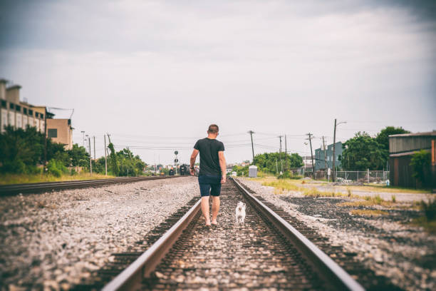 istock Man and His Dog Walking on the Tracks 1163915717