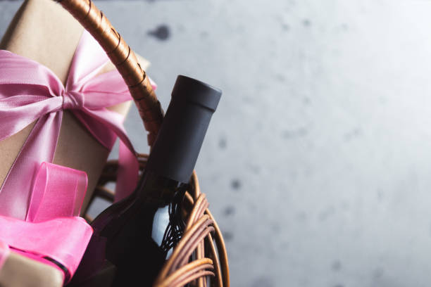 istock A bottle of red wine and a gift box with a bow in a basket with copyspace 1163916608