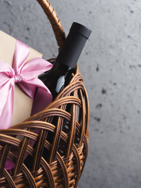 istock A bottle of red wine and a gift box with a bow in a basket with copyspace 1163916616