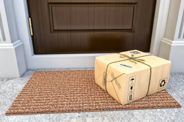 Parcel box wrapped in craft paper on the door mat near the entrance door