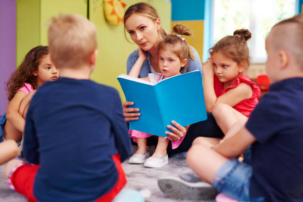istock Female teacher is reading a book during classes in preschool 1163918023