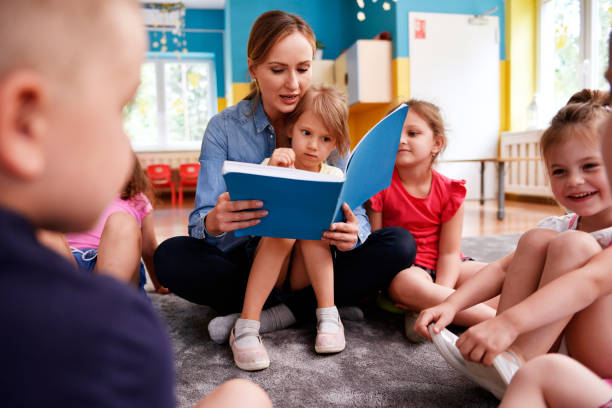 bambini e insegnanti che leggono un libro insieme in età prescolare - circle child preschool preschooler foto e immagini stock