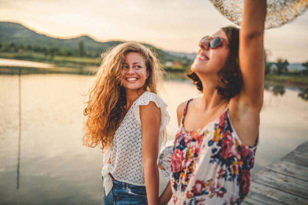 Best friends walking on wooden dock over the lake