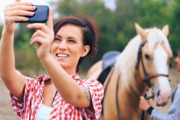 donna che si fa selfie con il cavallo - shirt checked women wild west foto e immagini stock