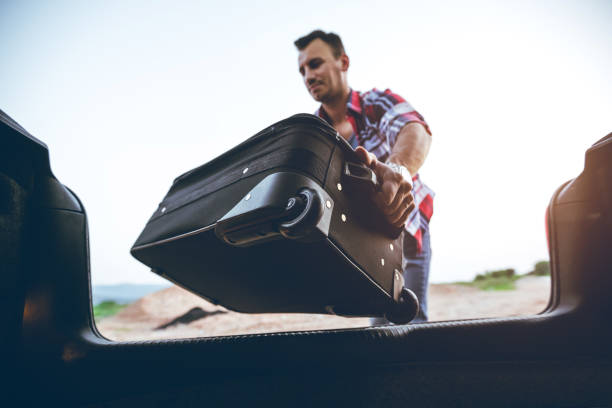istock Putting suitcase in car trunk 1163918822