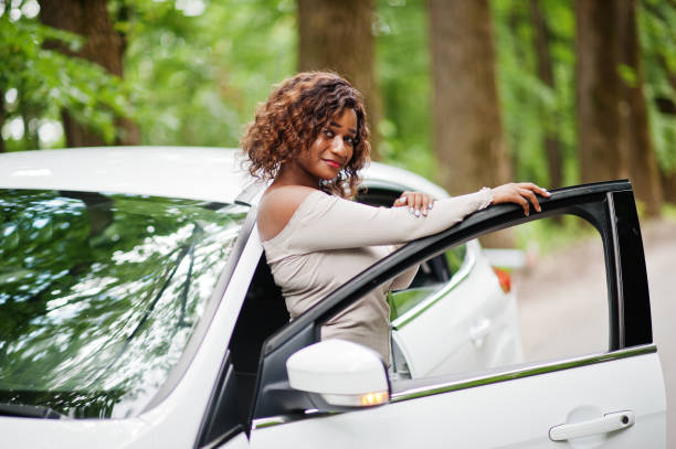 istock African american woman posed against white car 1163920156