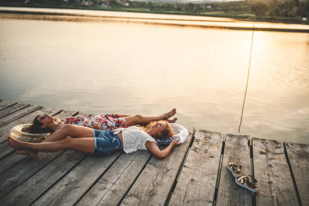 Best friends walking on wooden dock over the lake