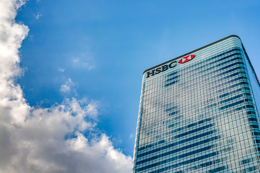 London, UK - July 31st 2018: HSBC Tower HQ (8 Canada Square) against the blue sky and clouds with copy space in Canary Wharf, London, England . It is the main headquarters of HSBC Bank