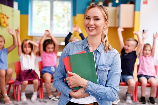 Smiling female teacher in the preschool Smiling female teacher in the preschool pre school teacher stock pictures, royalty-free photos & images