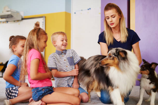istock Group of children having fun with dog during therapy 1163921507