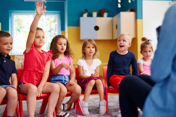 istock Girl raising her hand to ask question in classroom 1163921734