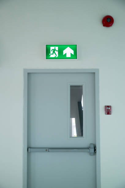 istock Sign : Emergency exit sign at path way indoor building public facility that emergency escape route is left. (fire, building, health or safety) require exit signs to be permanently lit 1163922423