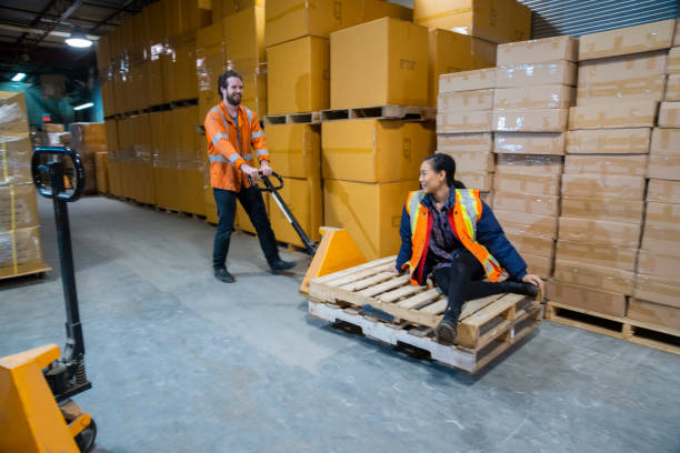 istock An industrial warehouse workplace safety topic.  Two employees playing around with a pallet jack and some pallets. 1163925667