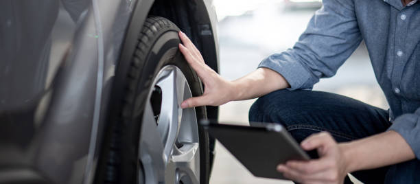 Auto mechanic checking the car using tablet Asian auto mechanic holding digital tablet checking car wheel in auto service garage. Mechanical maintenance engineer working in automotive industry. Automobile servicing and repair concept hybrid car photos stock pictures, royalty-free photos & images