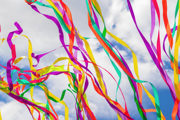 Bright multicolored ribbons develop against the sky. The concept of holiday design, fun.