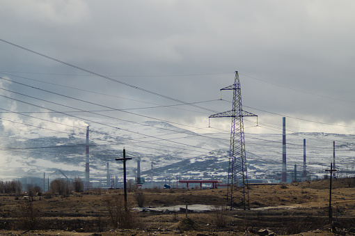 Mountain landscape background. snowy hills and forest. industrial power lines in mountains