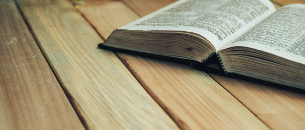 istock Close up open Bible book on a wooden table background. 1163929437
