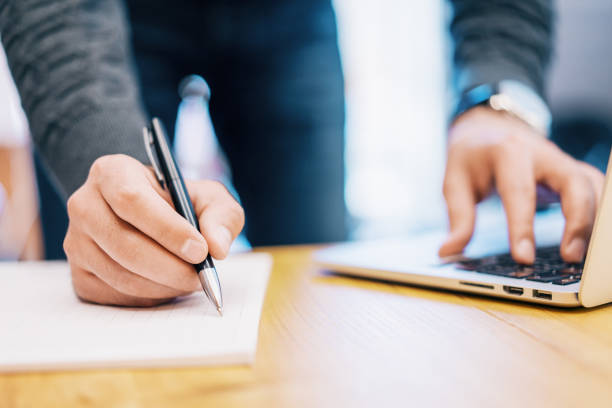 istock Sideview of male doing paperwork with laptop 1163931859